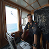Une main sur la commande du treuil, Yves Bernard de la Marine royale canadienne supervise le travail