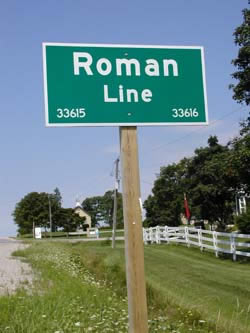 [ Roman Line Sign, 2005, Note St. Patrick's Roman Catholic Church in the background of the photograph.  Copyright Great Unsolved Canadian Mysteries Project, Jennifer Pettit,   ]